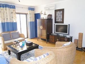 セジンブラにあるLuxuoso apartamento na praiaのリビングルーム(椅子2脚、テレビ付)