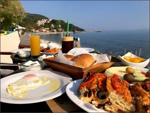 einen Tisch mit Teller mit Lebensmitteln und Meerblick in der Unterkunft Pansion Martha in Agios Ioannis