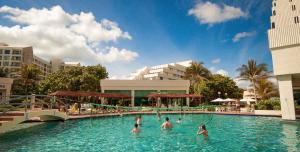 a group of people in the swimming pool at a resort at Beachfront Getaway Condo in Cancún
