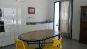 Casa Galana في بونتا موخيريس: مطبخ مع طاولة وبعض الكراسي الصفراء