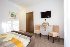 a bedroom with a bed and a table and chairs at Guest House Krk Town Centre in Krk