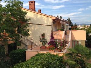 une maison avec des boîtes de fleurs sur les balcons dans l'établissement Guest House Krk Town Centre, à Krk