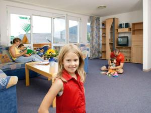 Ein kleines Mädchen steht im Wohnzimmer in der Unterkunft Wohnpark Schwarzwaldblick Bernau in Bernau im Schwarzwald