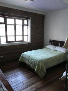 1 dormitorio con cama y ventana en Apartamentos Colonial Home, en Quito