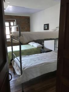 1 dormitorio con 2 literas y 1 silla en Apartamentos Colonial Home, en Quito