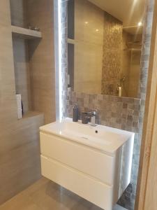 Un baño con un lavabo blanco y un espejo. en Domek Przy Źródełku, en Muszyna 56 fotos más