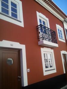 a orange building with a balcony and a door at Angra Downtown in Angra do Heroísmo