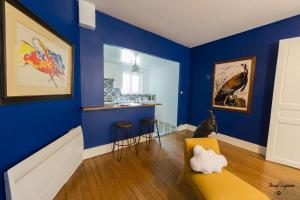 a room with blue walls and a bar with stools at Appartement aux remparts des Hospices in Beaune +13 photos