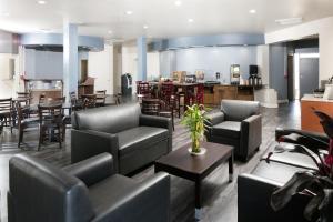 a living room with couches and tables and a kitchen at Red Lion Inn & Suites Tucson Downtown in Tucson