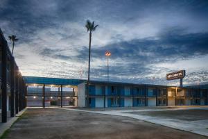 an empty parking lot in front of a hotel with a palm tree at Red Lion Inn & Suites Tucson Downtown in Tucson