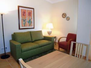 a living room with a green couch and a chair at Pestana Palm Gardens in Carvoeiro