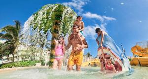 a group of people standing in the water at a water park at Beachfront Getaway Condo in Cancún +9 photos