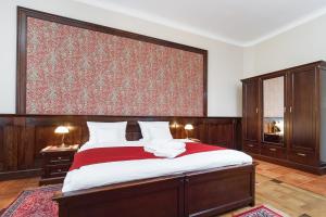 クラクフにあるエレガント アパートメントツのベッドルーム1室(赤毛布付きの大型ベッド1台付)