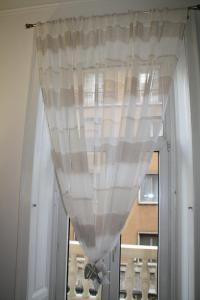 uma janela com uma cortina branca numa porta em LE COLONNE MILANO em Milão