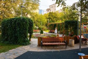 モスクワにあるDream House Novy Arbat 23のベンチと庭園に座る人々のいる公園