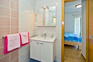 a bathroom with a white sink and a mirror at Luxurious Apartments Maslina with Beach in Milna