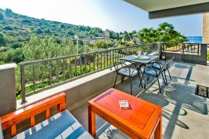 a patio with a table and chairs on a balcony at Luxurious Apartments Maslina with Beach in Milna