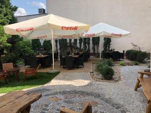 a patio with tables and umbrellas in a restaurant at Apartamenty Mieszczańskie u Gołębiewskich in Toruń