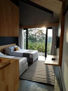 two beds in a room with a large window at Casa Du Vélo in Filandia