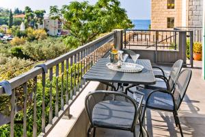 a table and chairs on a balcony with the ocean at Luxurious Apartments Maslina with Beach in Milna