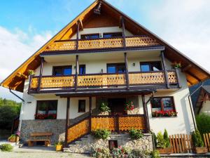 a house with a balcony with flowers on it at Willa Aurinia in Szczawnica
