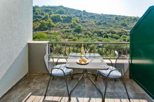 a table and chairs on a balcony with a view at Luxurious Apartments Maslina with Beach in Milna