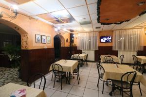 a dining room with tables and chairs and a tv at Pensiunea Baroque Slimnic in Slimnic