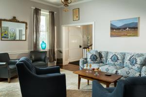 uma sala de estar com um sofá azul e cadeiras em L'Auberge Provencale Inn & Restaurant em Boyce