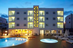 un hotel con piscina frente a un edificio en Ibiza Sun Apartments, en Playa d'en Bossa