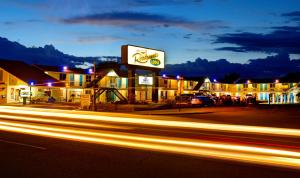 
a city street at night with a clock on the side of the street at Roadrunner Lodge Motel in Tucumcari
