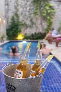 Trois bouteilles de bière dans un seau près de la piscine dans l'établissement República Hostel Cartagena, à Carthagène des Indes