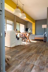 sala de estar con paredes amarillas y suelo de madera. en Comfy Kourouta Apartment & Suite, en Kourouta