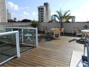 a deck with tables and chairs on a building at Marina Bezerril - 304 Pontamares - Pertinho de tudo,mar e restaurantes in Natal