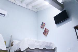um quarto com uma cama e uma televisão na parede em Casa Anita em Cartagena das Índias
