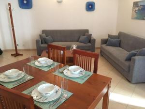 アルマカオ・デ・ペラにあるApartamento Azulのリビングルーム(テーブル、椅子、ソファ付)