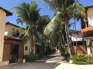 una calle con palmeras frente a un edificio en Bela casa de 4 suítes em Geribá, en Búzios