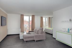 a living room with a couch and a bed at MARA Hotel in Ilmenau