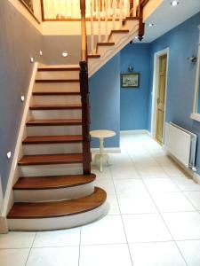 una escalera en una habitación con paredes azules y suelo de baldosa blanca en Luxury Skibbereen Town House en Skibbereen