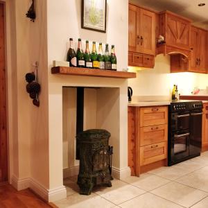 a kitchen with a fireplace with wine bottles on it at Luxury Skibbereen Town House in Skibbereen
