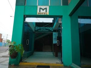 a green building with the entrance to a hotel at Meflo Playa Grande in Chala