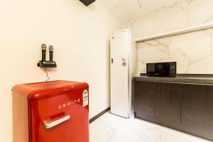 einen roten Kühlschrank in einer Küche neben einer Mikrowelle in der Unterkunft Plum Hotel in Siheung
