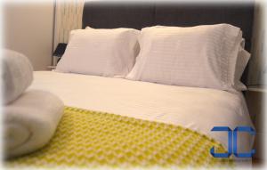 a bed with white sheets and white pillows at #Four Apartment by JC in Porto
