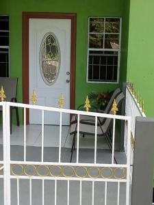 a front porch with a white fence and a door at Bougainvillea Apartments in Castries