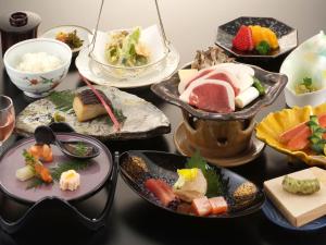 a table topped with different types of food on plates at Megahira Onsen Quelle Yoshiwa in Hatsukaichi