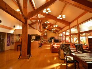 a large room with wooden beams and a living room at Megahira Onsen Quelle Yoshiwa in Hatsukaichi