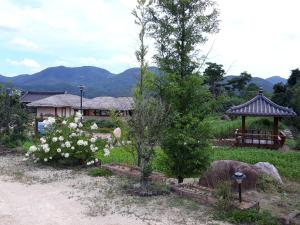 um jardim com um gazebo e flores brancas em Namuae Moon em Gyeongju