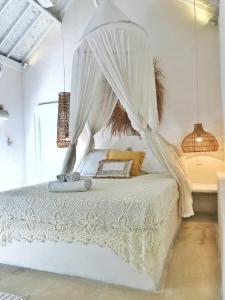 a bedroom with a white bed with a canopy at Sal Secret Spot in Uluwatu