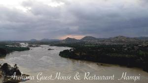 a view of a river with mountains in the background at Archana Guest House River View in Hampi