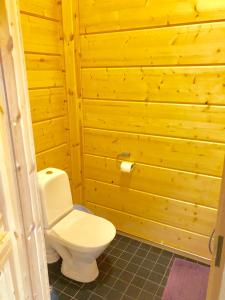 een badkamer met een toilet in een houten muur bij Mikala in Karstula