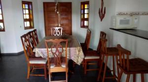 a kitchen with a table with chairs and a microwave at Chácara Vale Eldorado in Bragança Paulista